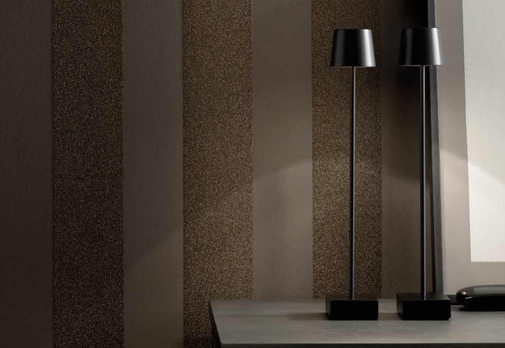 Granulattapete SAHCO Lavina. Der Fond besteht aus einem matten vollflächigen Farbauftrag. Die einzelnen Streifen werden mit Klebepaste aufgedruckt und mit einem Granulat aus geriebenen Steinen und Goldpartikeln versehen. Granulattapete SAHCO Lavina. Der Fond besteht aus einem matten vollflächigen Farbauftrag. Die einzelnen Streifen werden mit Klebepaste aufgedruckt und mit einem Granulat aus geriebenen Steinen und Goldpartikeln versehen.