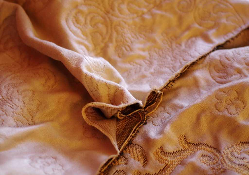 Schnitt eines Doppelgewebes, hier zu sehen in Bildmitte die Ober- und Unterseite getrennt. Die verbindenden Polfäden ergeben im Gewebe das Muster. Schnitt eines Doppelgewebes, hier zu sehen in Bildmitte die Ober- und Unterseite getrennt. Die verbindenden Polfäden ergeben im Gewebe das Muster.